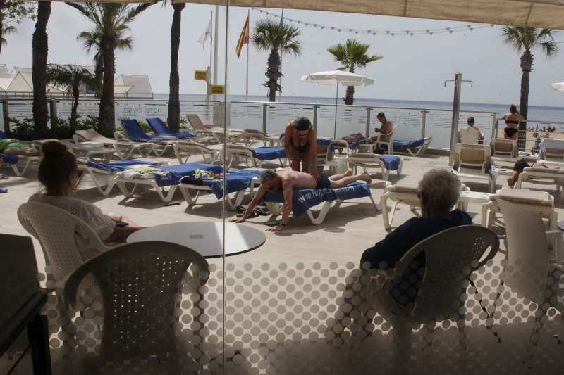 Varias personas disfrutan del buen tiempo en un hotel junto a la playa de Benidorm. Archivo/ EFE/ Morell
