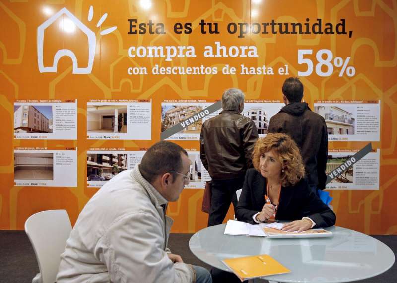 Una vendedora da informaciÃ³n a un posible comprador en una feria inmobiliaria. EFE/Manuel Bruque/Archivo
