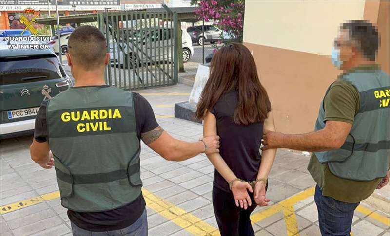 Dos agentes custodian a la mujer detenida en Bigastro (Alicante) tras la muerte de su hijo de 27 meses.EFE/ Guardia Civil
