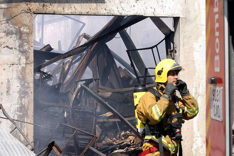 Un bombero sale de una fÃ¡brica totalmente destruida por un incendio. EFE/Morell/Archivo
