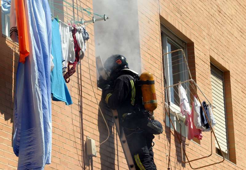 Un bombero llega desde una escalera al foco del incendio declarado en un edificio en Alicante. Archivo/EFE/Morell