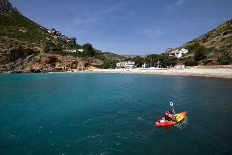 Una persona pasea en kayak en la cala de la Granadella (Jvea). EFE Natxo FrancsArchivo