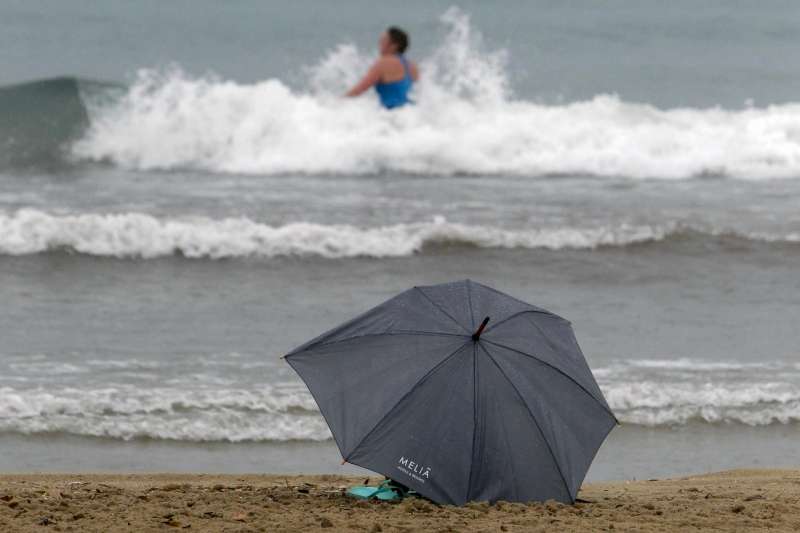 Una persona se baa bajo la lluvia en las aguas de la playa de El Postiguet de Alicante. EFEMorell