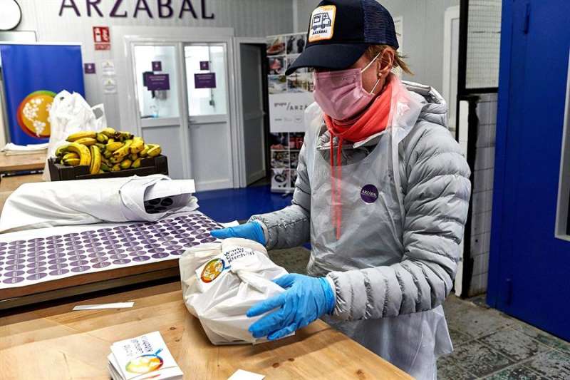 Una persona comprando en Valencia con guantes y mascarilla. EFE