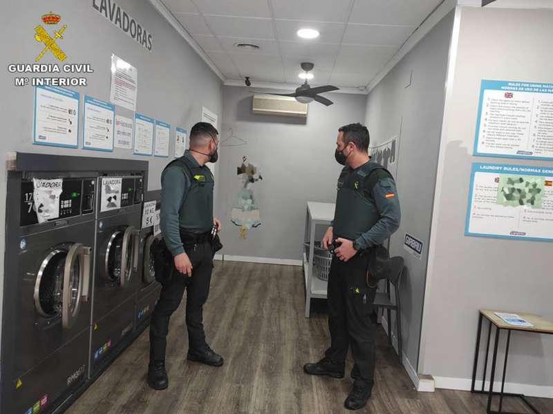 La Guardia Civil, en una de las lavanderías atracadas. /EFE