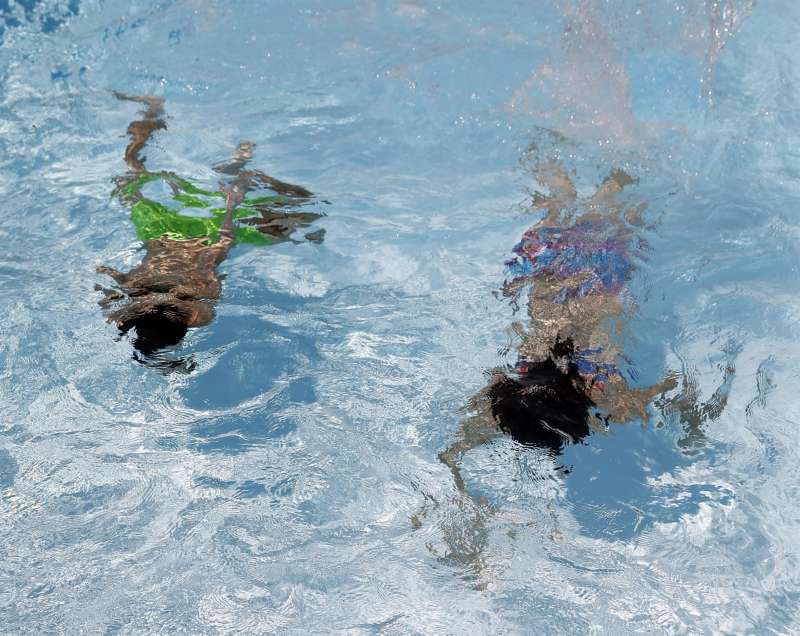 En la imagen, dos personas se refrescan en el interior de una piscin. EFE/J.J. Guillén/Archivo