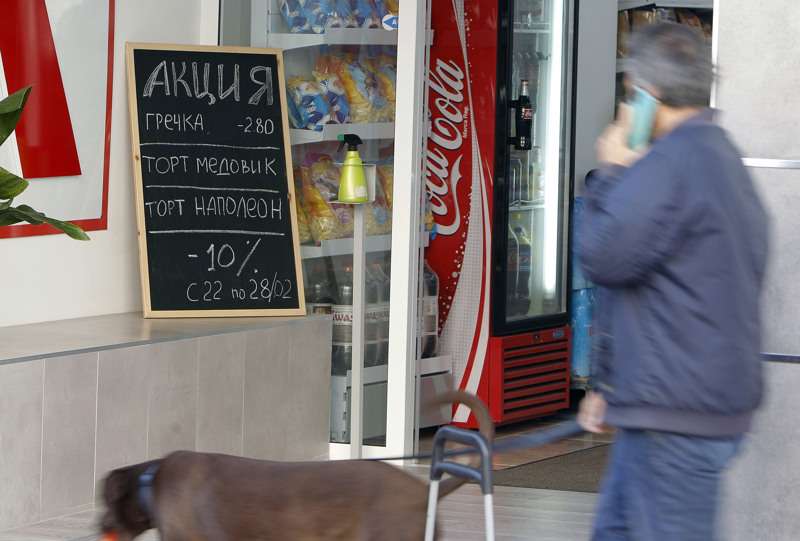 Una persona pasa por un supermercado español rotulado en ruso. /EFE
