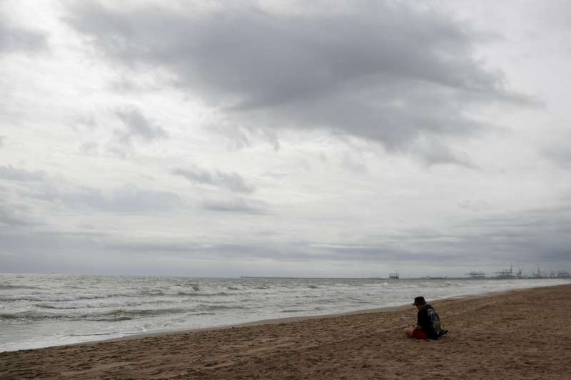 Una persona en la playa bajo un cielo nublado este martes. EFEManuel Bruque