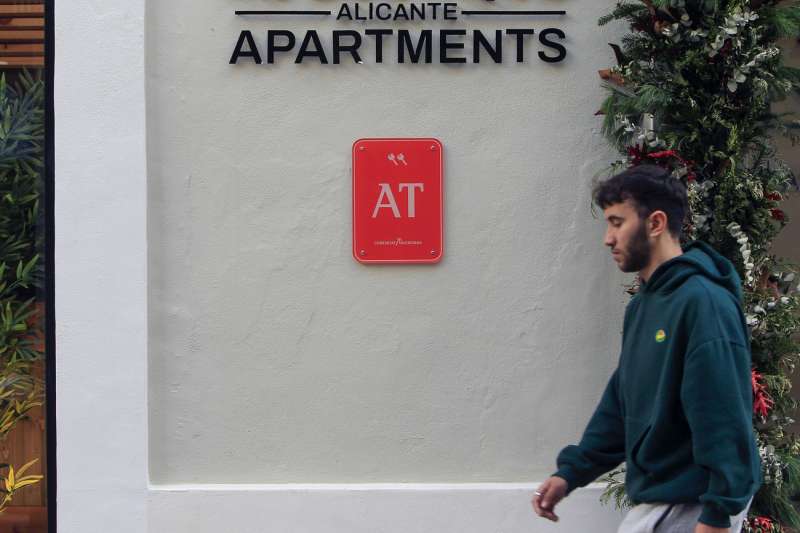 Un joven pasa ante un edificio de apartamentos de Alicante. EFE Morell
