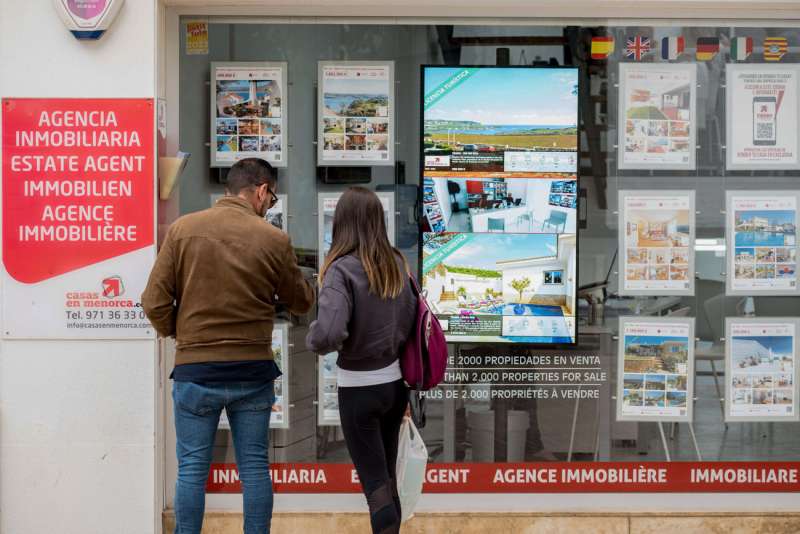 Una pareja se detiene a observar las propiedades en venta anunciadas en el escaparate de una agencia inmobiliaria. EFE/ David Arquimbau Sintes/Archivo
