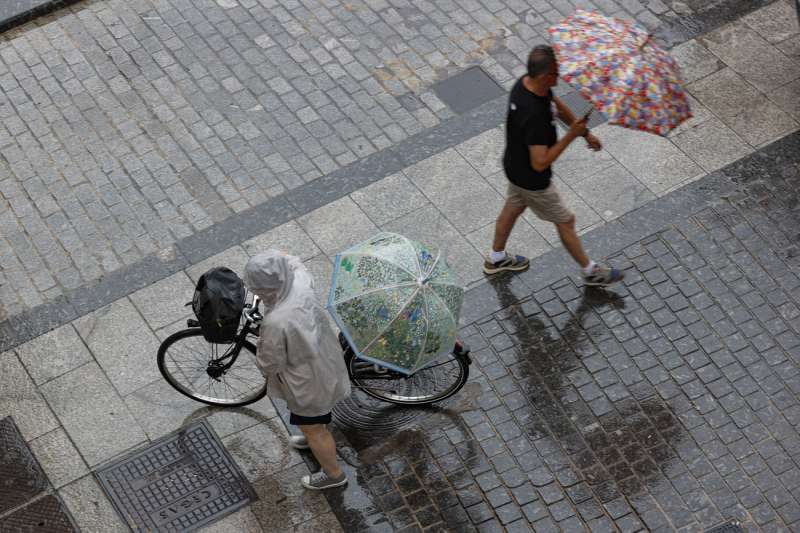 Dos personas caminan bajo la lluvia en una calle de Valencia este sbado. EFEManuel Bruque
