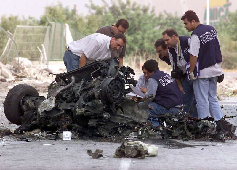 Varios guardias civiles examinan los restos del coche bomba que explotÃ³ en Santa Pola en 2002.  /EFE