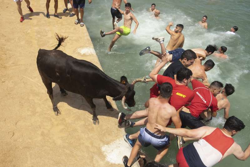 Varias personas saltan al agua durante la celebración en Dénia (Alicante) de su tradicional festejo 