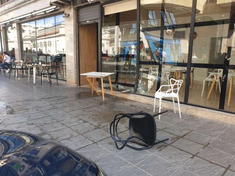Estado en el que ha quedado la cristalera del local y los muebles de terraza por el choque, en una imagen compartida por la Policía Local de Orihuela.
