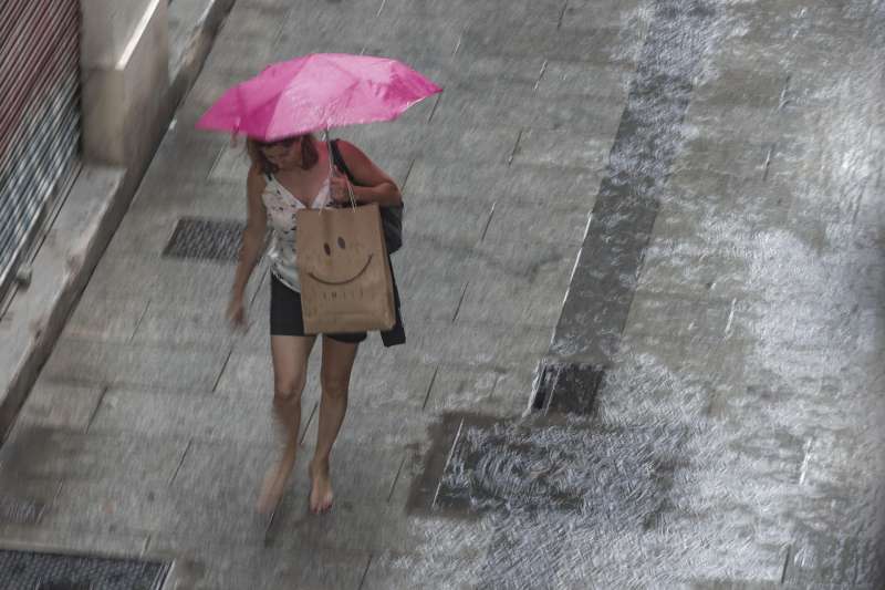 Una mujer camina bajo la lluvia. EFE/Manuel Bruque/Archivo
