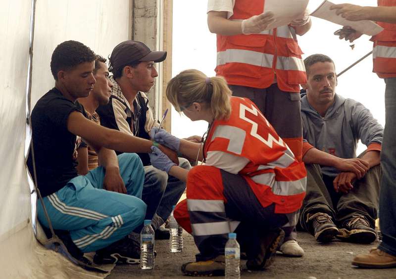 Miembros de la Cruz Roja atienden a las personas que viajaban en una patera. EFE/ Morell/Archivo

