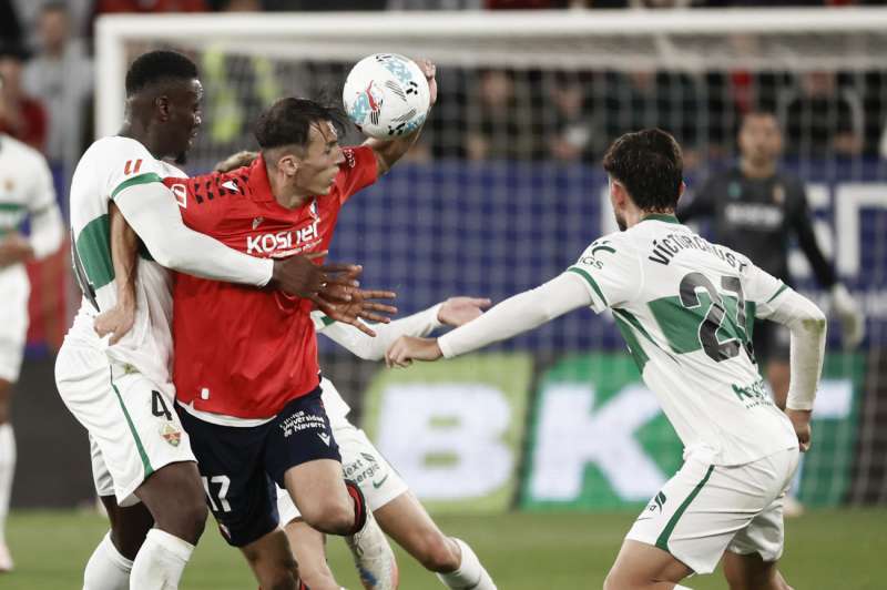 El delantero del Osasuna Ante Budimir (2i) pelea por el baln con los defensas del Elche, Victor Chust (dcha), y Bambo Diaby, durante el partido de la jornada 6 de Liga que disputan este jueves ante el Osasuna en el estadio El Sadar en Pamplona. EFEJess Diges
