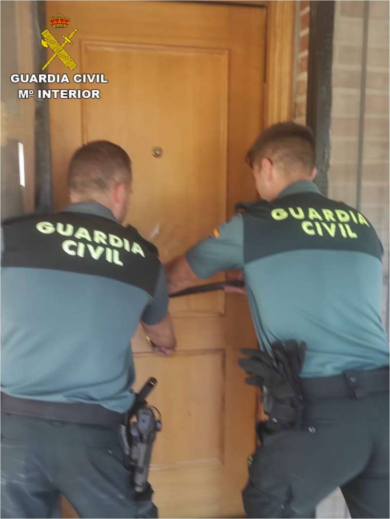Dos agentes de la Guardia Civil forzando la puerta de una vivienda. /EPDA