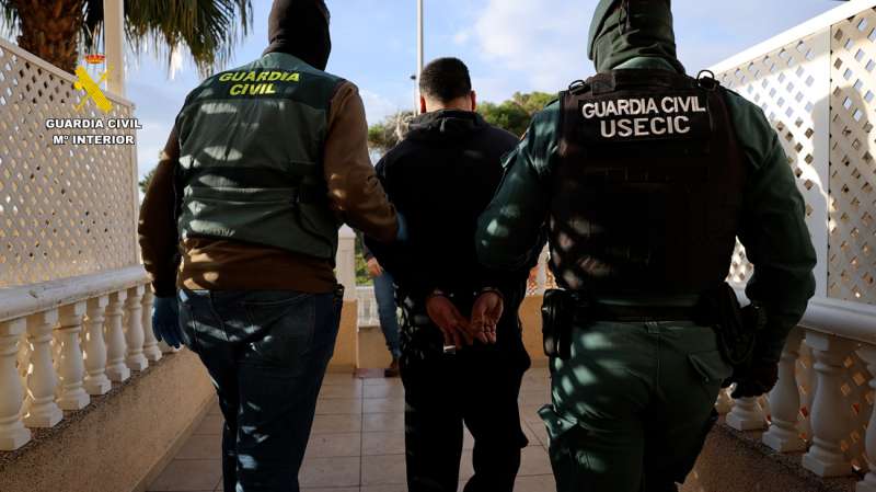 El detenido, escoltado por dos agentes, en una imagen difundida por la Guardia Civil. /EPDA 
