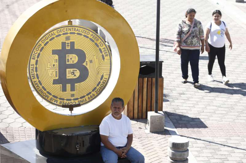 Imagen de archivo de un hombre esperando junto a un medall�n con el s�mbolo de bitc�in. EFE Rodrigo Sura

